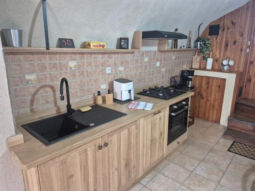 a kitchen with a sink and a stove at Au Pied des Remparts in Villeneuve