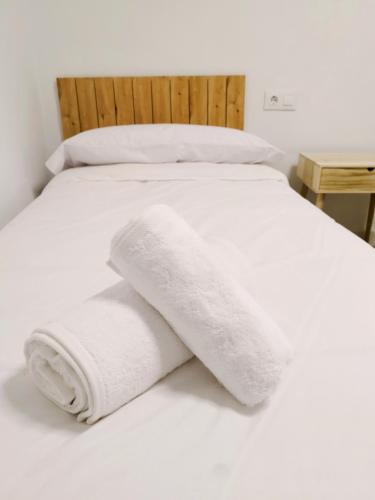 a white bed with two white towels on it at La Casita de Isabel, Near Ronda, Sierra de Grazalema in Montecorto