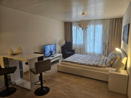 a bedroom with a bed and a desk and a window at Holiday Apartments Walter in Interlaken
