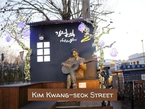 a statue of a man playing a guitar in front of a building at Private House Good Stay Samdeok in Daegu
