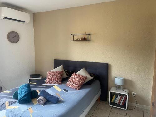 a bedroom with a bed with blue sheets and pillows at Studio Climatisé et Grande Terrasse Tarbes Centre in Tarbes