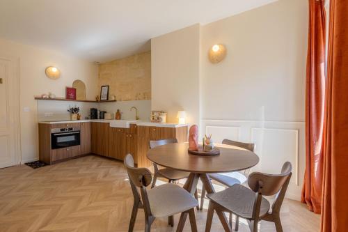 une cuisine avec une table et des chaises dans une pièce dans l'établissement L'Intimiste Marché des Capucins, à Bordeaux