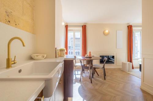 une cuisine avec un grand évier et une table dans l'établissement L'Intimiste Marché des Capucins, à Bordeaux