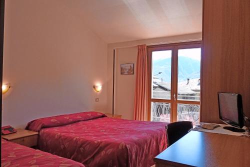 テーリオにあるHotel La Rosaのベッドが2つと窓があるホテルの部屋