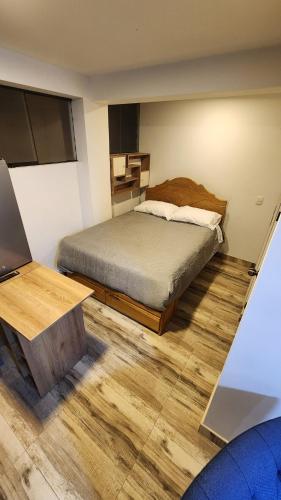 a bedroom with a bed and a desk with a laptop at Atractivo y genuino monoambiente in Pisac