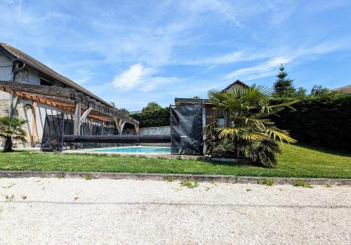 une maison avec une piscine à côté d'un bâtiment dans l'établissement La Grange de Jannine et Clémentine, à Saint-Germain-la-Chambotte