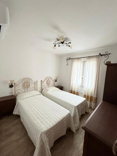 a bedroom with two beds and a ceiling fan at Budoni residence Lutturai 4 in Budoni