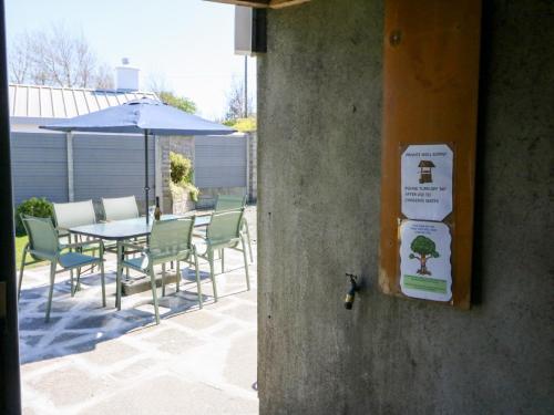 a sign on a wall with a table and chairs at Maulnagirra in Leap