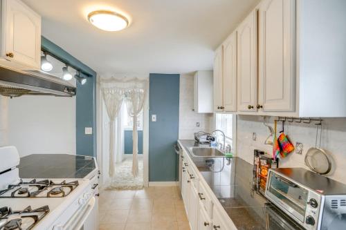 a kitchen with white cabinets and a sink and a stove at Trail Access Berkshires Gem with Rooftop Deck! in Lee