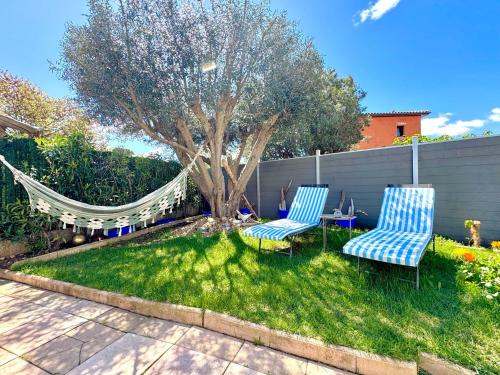 - deux chaises et un hamac dans une cour avec un arbre dans l'établissement Coco Lodge Home, maison cosy entre mer et nature !, à Vic-la-Gardiole