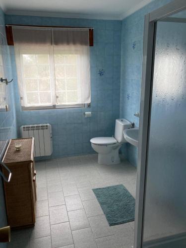 a blue bathroom with a toilet and a sink at Casa Sindo in Teixeira