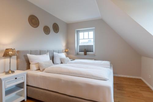 a bedroom with a white bed and a window at Diekhus SPO Diekhus 3 in Böhl