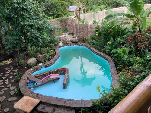 a swimming pool with a slide in a garden at Under the mango tree at Klipp Residence in Talay