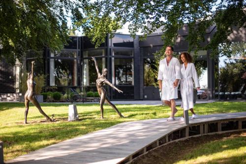 a man and two women standing in front of a statue at Domaine Des Hautes Fagnes in Ovifat