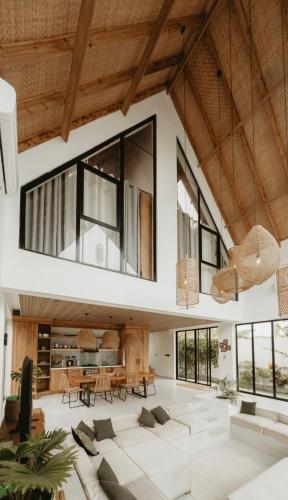 an open living room with large windows and a table at abode II Zanzibar in Paje