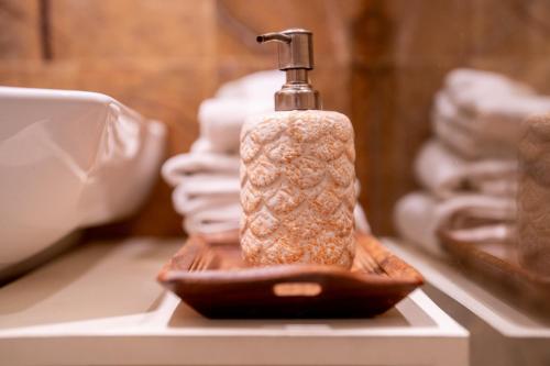 a bottle of soap sitting on a shelf with towels at Dera Jaipur Homestay in Jaipur