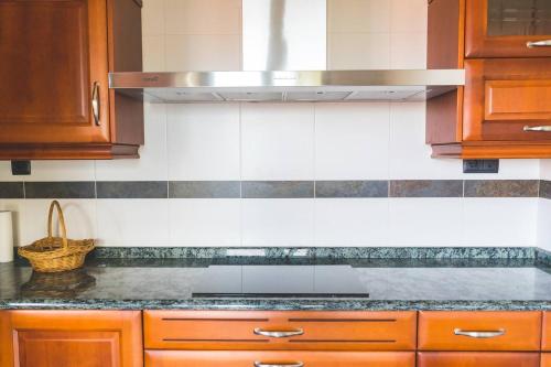 a kitchen with wooden cabinets and a stove top oven at Pantin Beach View Villa Pool Aloha-te in Pantín