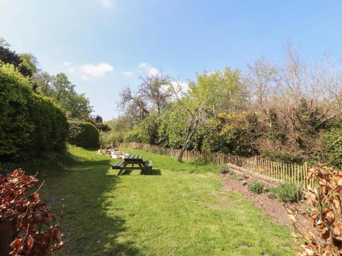 a picnic table in the grass next to a fence at The Coach House in Llangollen