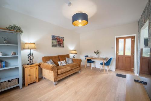 a living room with a couch and a table at Fort William Cottage ,11 Torlundy Courtyard in Torlundy