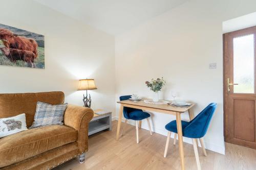 a living room with a couch and a table at Fort William Cottage ,11 Torlundy Courtyard in Torlundy
