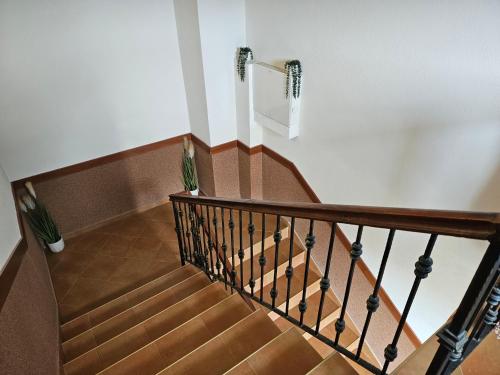 a stairwell with a wooden railing and a stair case at Cтаи за гости Бърдареви in Bansko