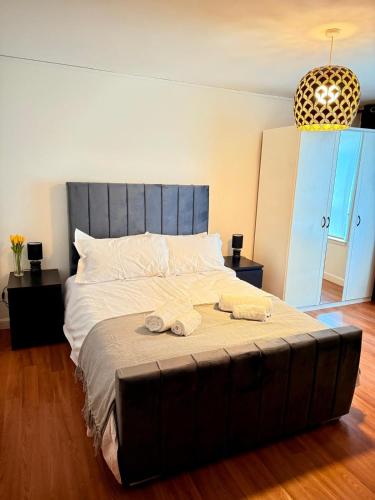 a bedroom with a large bed with two towels on it at 2 Bedroom Apartment near Glasgow City Centre, Celtic Park and Emirates Arena in Glasgow