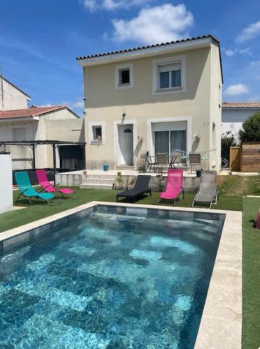 une maison avec une piscine devant une maison dans l'établissement Villa ensoleillée avec piscine route des plages, à Aimargues