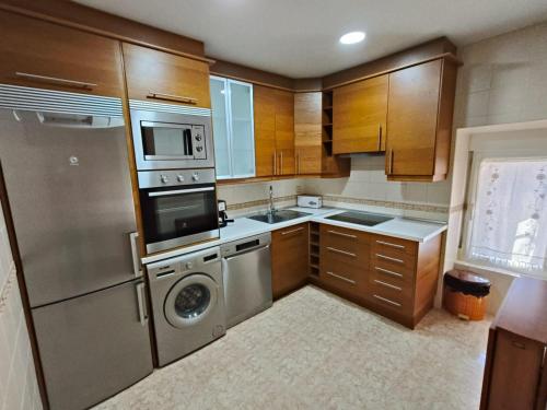 a kitchen with a stainless steel refrigerator and a dishwasher at Casa Buenavista in Las Navas del Marqués