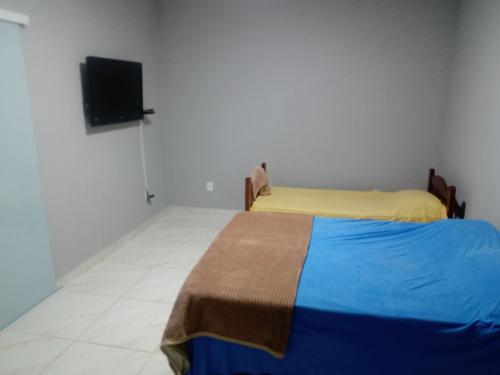 a bedroom with a bed and a flat screen tv at Recanto dos Mineiros in Monte Alegre do Sul