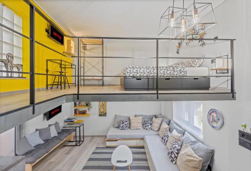 a living room with a couch and a bed in a loft at Kyma Holiday Loft in Artemida