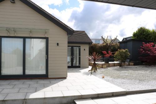 a house with a large sliding glass door at Luxury 2 bedroom property in quiet location close to SW Coastal Path in Paignton