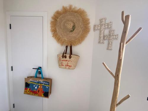 un mur avec une croix et un panier sur un mur dans l'établissement MarinesAppartement, Beach Duplex, à Saint-Tropez