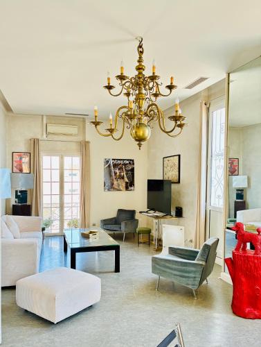 a living room with a chandelier and a couch at Les Remparts Antibes Location in Antibes