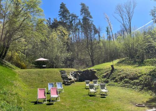 a group of lawn chairs sitting in the grass at Hotel-Restaurant Faustschlössl in Feldkirchen an der Donau