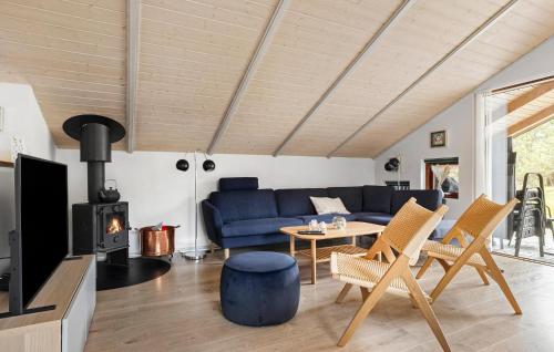 a living room with a blue couch and a fireplace at Holiday Home Ingeborgvej Løkken Xii in Grønhøj