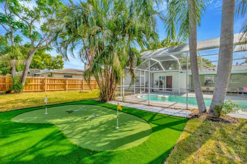 a golf course in front of a house with palm trees at Breezy Pineapple, Heated Pool, Sleeps 12, Putting Green in Largo