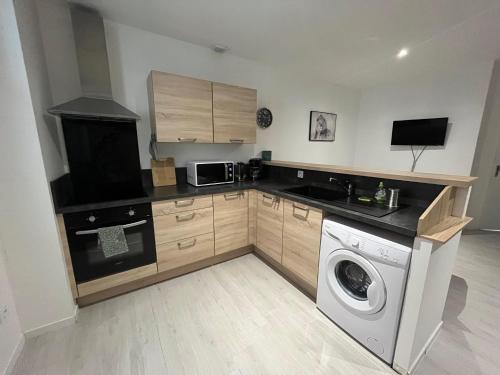 une cuisine avec un lave-linge et un micro-ondes dans l'établissement Lourdes : Superbe T2 42m2, à Lourdes