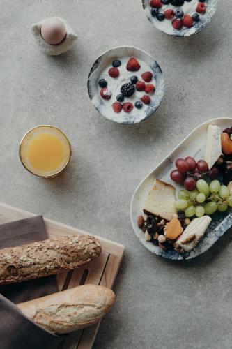 a table with plates of cheese and fruit and bread at Au Porte Bonheur in Zwalm