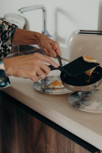 a person is preparing food in a pan on a plate at Au Porte Bonheur in Zwalm
