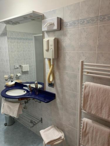 a bathroom with a blue sink and a mirror at Hotel La Bussola in Orta San Giulio