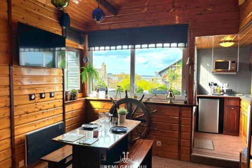 une cuisine avec une table et une grande fenêtre dans l'établissement The Boat Central Terrace Retreat 2 Guests, à Honfleur