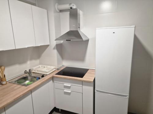 a white kitchen with a sink and a refrigerator at Habitacion BNB con balcon Alfarooms in Albacete