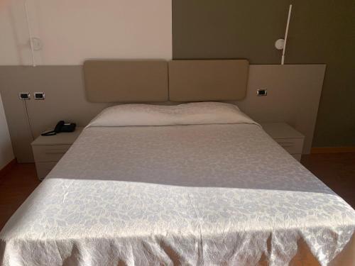 a bed with a white bedspread on it in a room at Hotel La Bussola in Orta San Giulio