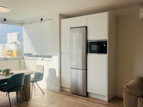 a kitchen with a refrigerator and a table with chairs at Mi casa vacacional en Valdelagrana in El Puerto de Santa María