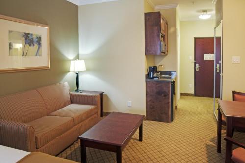a living room with a couch and a table at Holiday Inn Express Hotel & Suites Winnie by IHG in Winnie