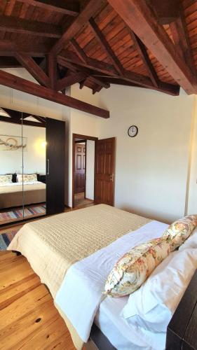 a bedroom with a large bed with a wooden ceiling at Alexander Dion House in Afitos