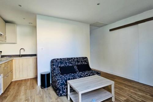 un salon avec un canapé et une table dans l'établissement Apartment 2 rooms with garden in La Rochelle, à La Rochelle