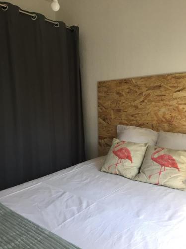 - une chambre dotée d'un lit avec deux oiseaux rouges sur oreillers dans l'établissement T2 Piscine, parking et clim à sanary, à Sanary-sur-Mer