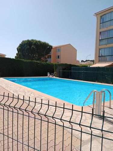 une piscine entourée d'une clôture dans l'établissement T2 Piscine, parking et clim à sanary, à Sanary-sur-Mer
