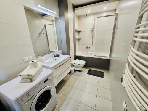 W białej łazience znajduje się pralka. w obiekcie Apartament z widokiem na Wawel w centrum miasta w Krakowie